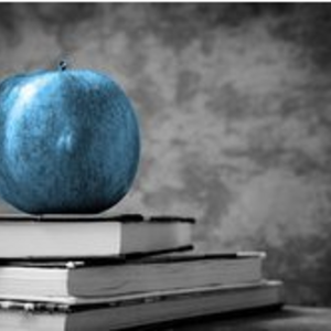 Schwarz/ weiß Bild von Bücherstapel, auf dem blau akzentuierter Apfel liegt.