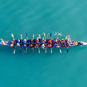 Dragon Boat Team Rudert im Tempo eines Bordtrommlers, Luftaufnahme