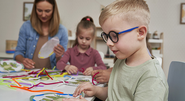 eine Lehrkraft macht sensorische Übungen mit  Kindern 