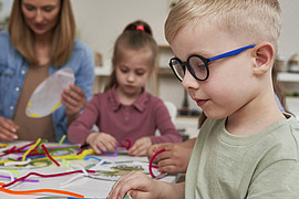 eine Lehrkraft macht sensorische Übungen mit  Kindern 