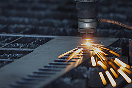 Nahaufnahme eines Lasers auf Metall mit kleinen Funken