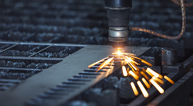 Nahaufnahme eines Lasers auf Metall mit kleinen Funken