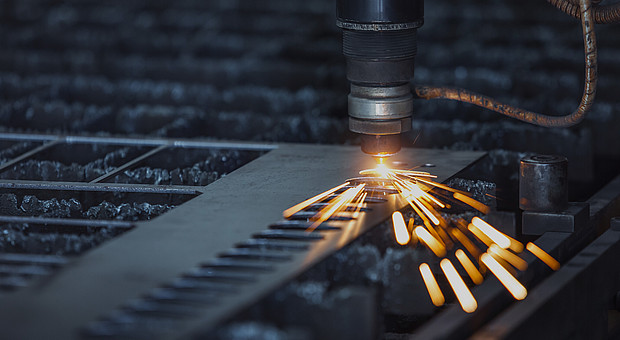 Nahaufnahme eines Lasers auf Metall mit kleinen Funken