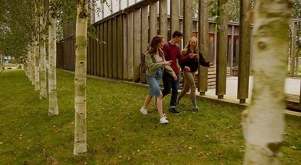 Drei Studierende gehen an der Campelle der Europa-Universität Flensburg vorbei 