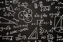 Eine schwarze Tafel mit Mathematischen Formeln. 