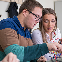 zwei Studierende arbeiten praktisch an Technik während eines Seminars 