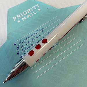 Foto mit einem Briefumschlag Priority mail und einem Kugelschreiber 