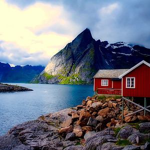 Bild von einem Haus am See mit Bergen