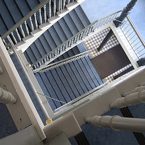 Treppenhaus eines Gebäudes mit mehreren Stockwerken von oben fotografiert