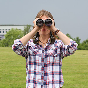 Bild einer Frau mit Fernglas auf dem Campus Flensburg