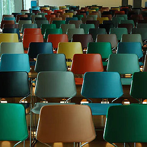 Foto eines Auditoriums mit vielen bunten Stuhlreihen.