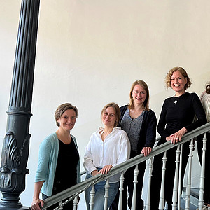 Gruppenfoto von vier Frauen und zwei Männern im Treppenhaus des Universitätsgebäudes Madrid.