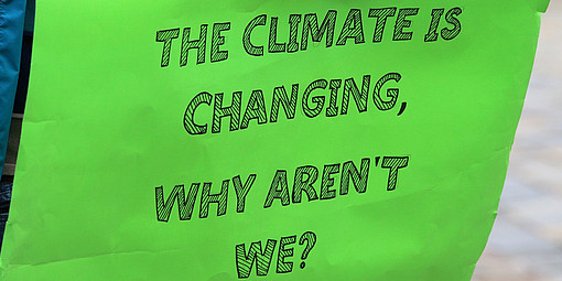 Grünes Plakat mit dem Spruch Das Klima verändert sich, warum wir nicht