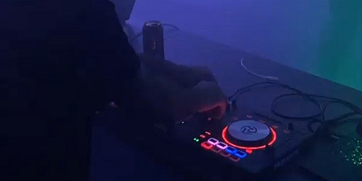 DJ spielt Rave-Musik mit Lila-Lichtern