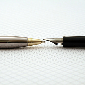 Foto zeigt liegenden Kugelschreiber und liegenden Füller