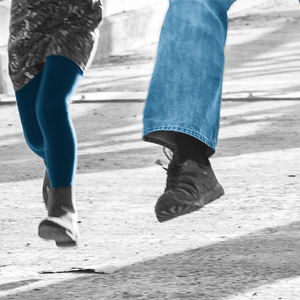 Das Foto zeigt 2 Erwachsene und 2 Kinder, die laufen oder hüpfen etwa ab Brusthöhe bis zu den Füßen
